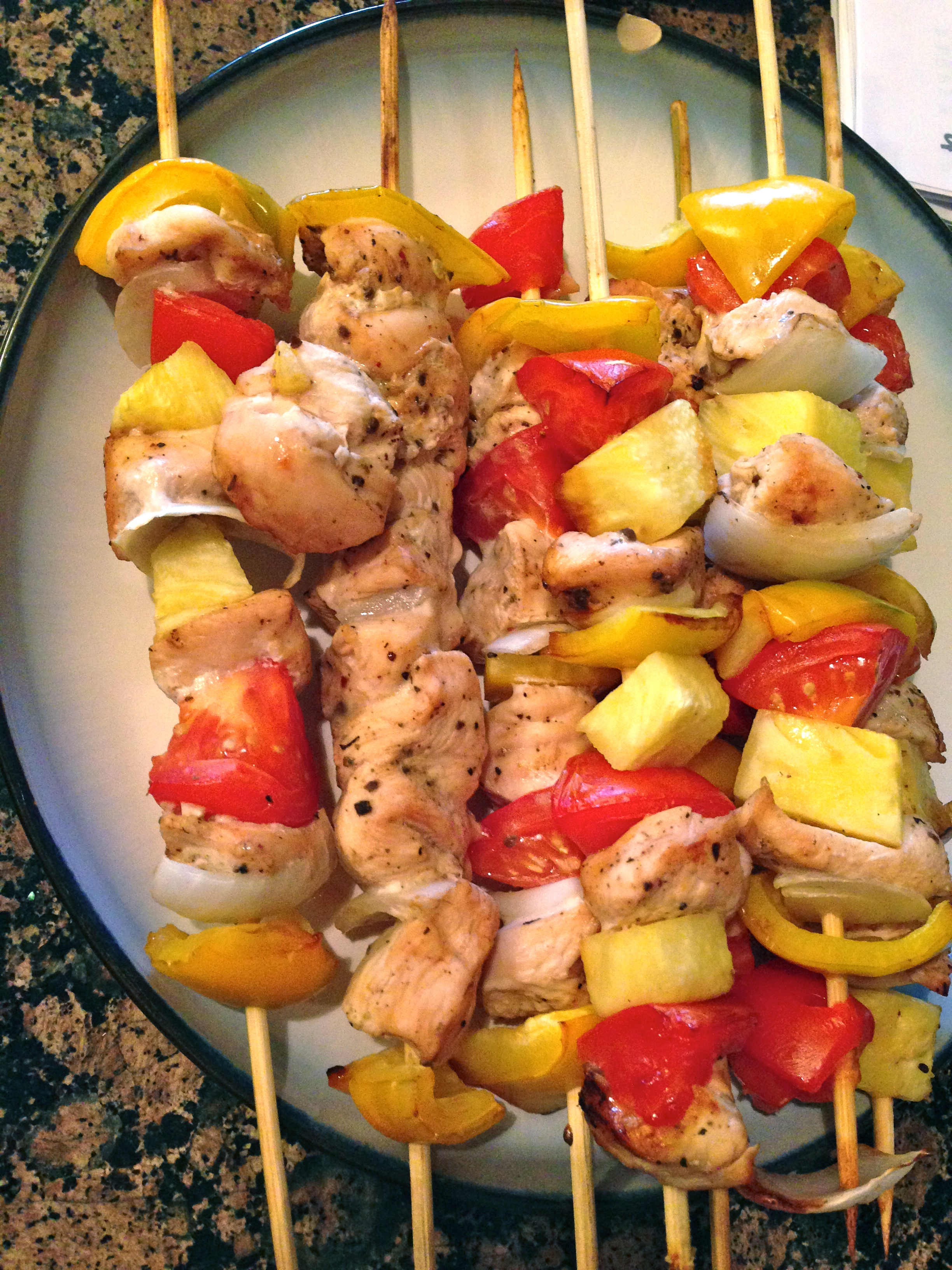 plate with stacked and cooked pineapple chicken kabobs