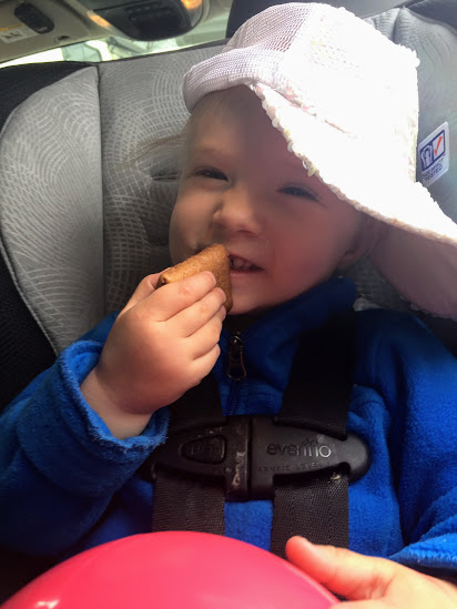 Zoey in the car with her sparkle hat and snack