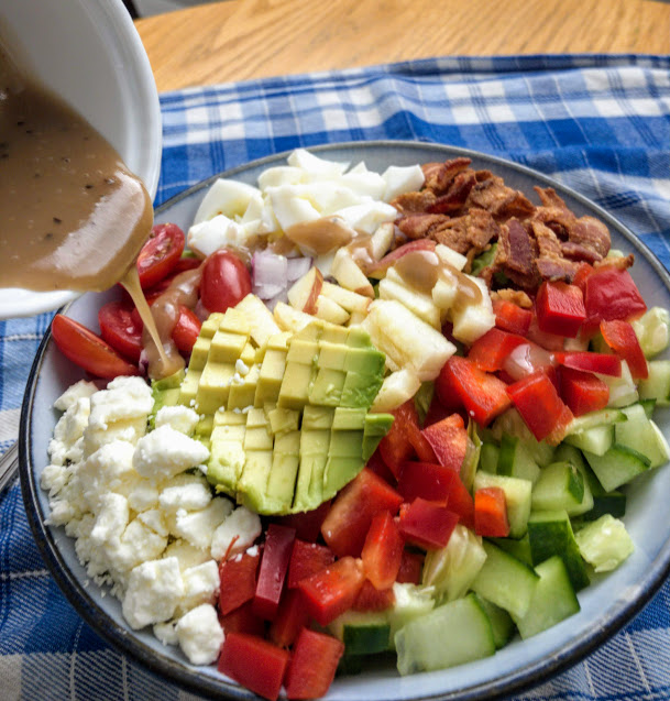 Lightened Up Cobb Salad with Dressing Being Put on