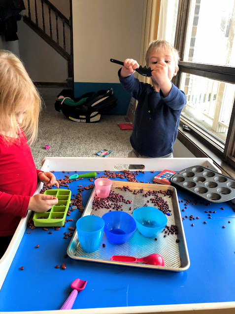 Boy playing in dry bean sensory table for no screen activities for kids
