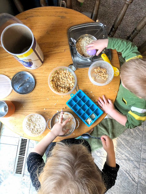 Girl and boy from above playing in oats and water sensory bin for no screen activities for kids
