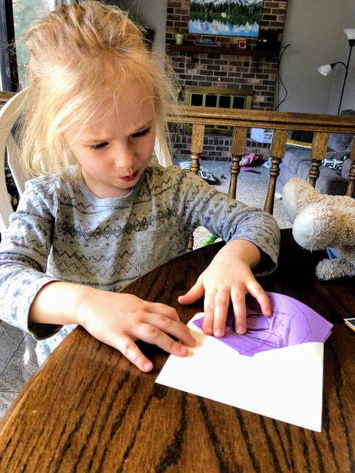 Girl filling an envelope for  simple dramatic play ideas for young kids
