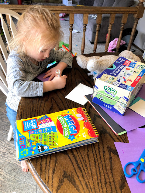 Girl writing letters for a post office for no screen activities for kids