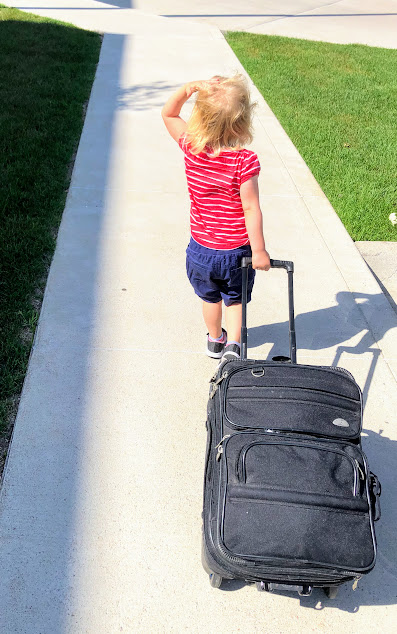 little girl pulling a suitcase