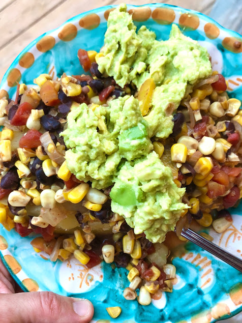 blue plate with potatoes, corn, beans, peppers, and avocado