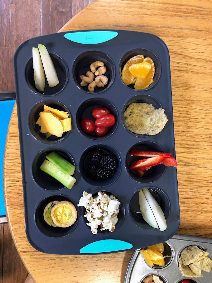 Muffin pan meal with pears, cashews, oranges and more