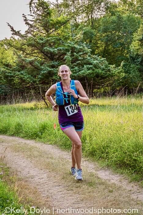 Woman running an ultra race with a hydration pack