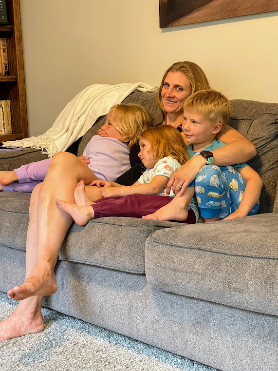 Mom and three kids on the couch watching a movie