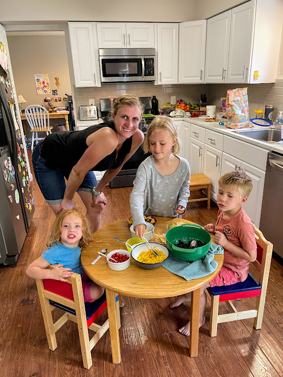 mom and three kids making loaded nachos