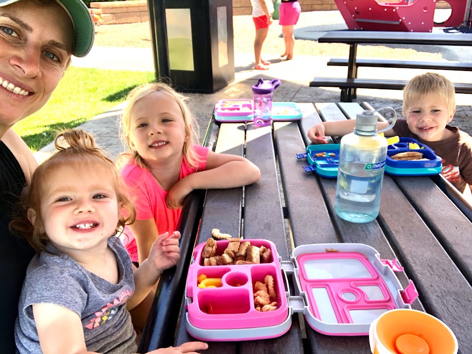 Mom and three kids having a picnic in lunch boxes to spend more time your kids