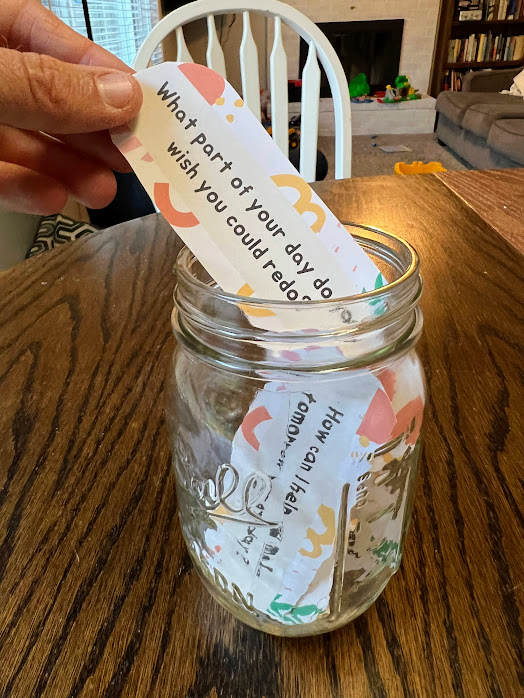 family conversation starters in a mason jar with one being pulled out