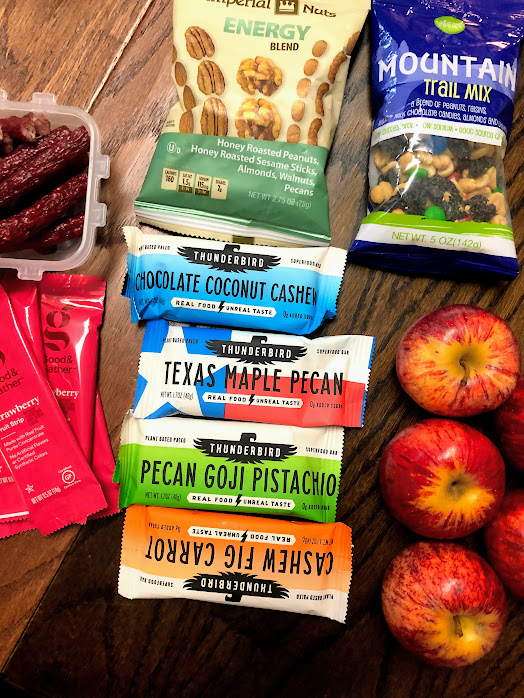 multiple snacks laid on a table for a road trip with kids