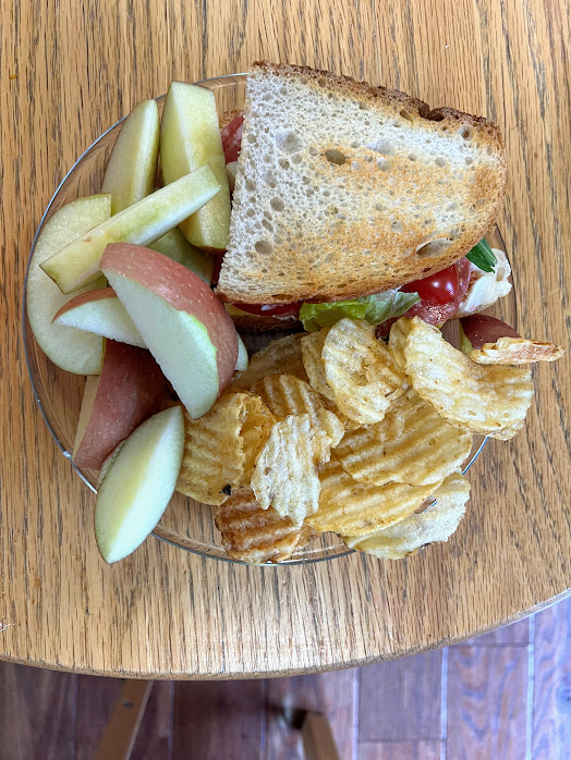 sandwich on toasted bread with sliced apple and chips