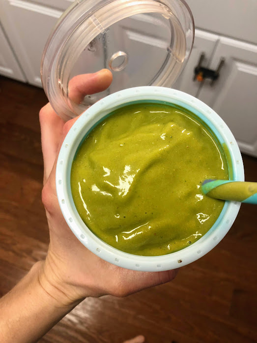green smoothie in a cup with straw