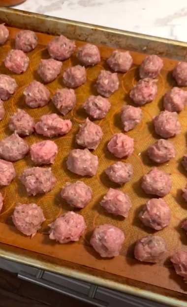 Turkey meatballs with chopped spinach on a pan