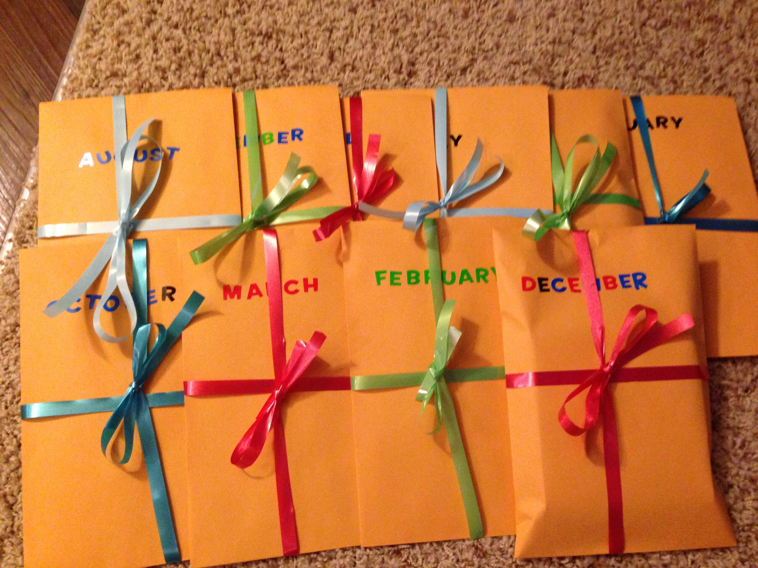 12 months of date nights in manila envelopes with the month on them and a ribbon